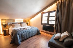 1 dormitorio con cama, ventana y sofá en Borda Conangle Mountain Lodge en Sant Julià de Lòria