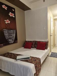 a bedroom with two beds with red pillows at Wind Residences in Tagaytay