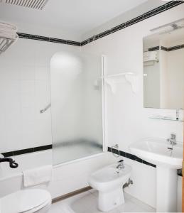 a white bathroom with a toilet and a sink at Hotel Tugasa Villa de Algar in Algar