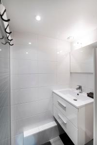 a white bathroom with a sink and a shower at Paris 5e entre Notre Dame & Pantheon in Paris