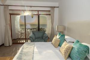 a bedroom with a bed with a view of the ocean at Sultan Palace Beach Retreat Mombasa in Mombasa