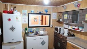 a kitchen with a white refrigerator and a sink at "Mi Hostal Tu Casa" Hostal Familiar SOLO EMPRESAS, TURISTAS y VIAJEROS Espacio para BICICLETAS y MOTOS in Puerto Montt
