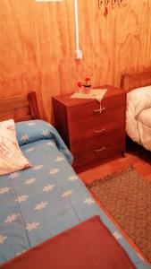 a bedroom with a bed and a wooden dresser at "Mi Hostal Tu Casa" Hostal Familiar SOLO EMPRESAS, TURISTAS y VIAJEROS in Puerto Montt