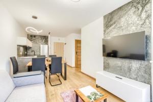 a living room with a couch and a dining room at Horyzont Apartamenty - NAVIGATOR- możliwość wykupienia śniadań!!! in Kołobrzeg