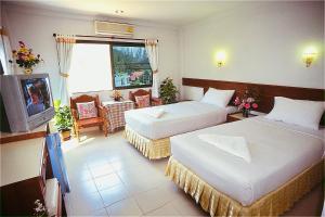a hotel room with two beds and a television at J Mansion in Ao Nang Beach