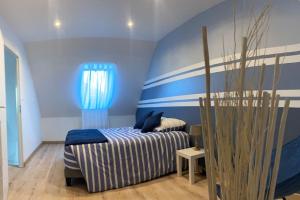 um quarto com uma cama com riscas azuis e brancas em Entre terre et mer em Écault