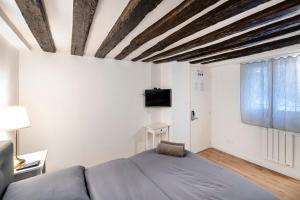 ein Schlafzimmer mit einem Bett und einem TV an der Wand in der Unterkunft Paris Place Pantheon in Paris