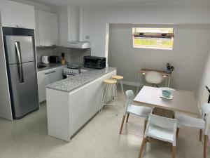 a kitchen with a refrigerator and a table with chairs at Las Maras Apart. in Rada Tilly