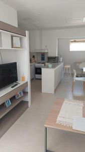 Habitación blanca grande con cocina y mesa. en Las Maras Apart. in 