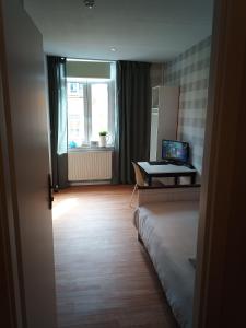 een kamer met een bed en een bureau met een laptop bij zur Friedrichsruh in Oelsnitz