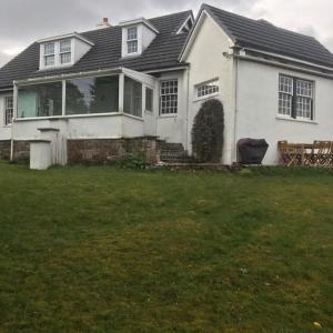 uma casa branca com um alpendre e um quintal em Craigievern Cottage em Drymen