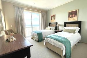 DʼAlmeida的住宿－Luxury at Pinnacle Point - 3 Bedroom Villa，酒店客房设有两张床和大窗户。