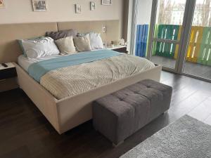 uma cama grande com um repousa-pés num quarto em 3bedroom Smarthome apartment, close to city center em Zielona Góra