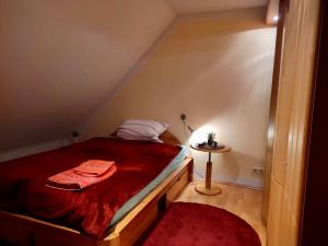 a small bedroom with a bed with a red blanket at Habitat Himmelgeist in Düsseldorf