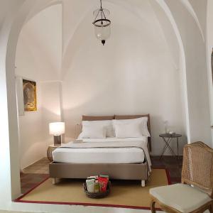 ein Schlafzimmer mit einem Bett und einem Stuhl in der Unterkunft Agata Salento Luxury Home in Matino