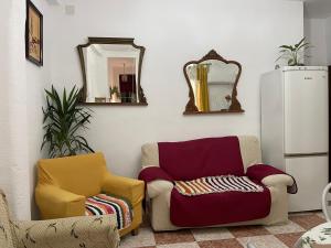 a living room with two chairs and a mirror at Vallaindiano in Córdoba