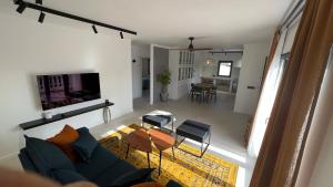 ein Wohnzimmer mit einem blauen Sofa und einem Tisch in der Unterkunft Casa Goldberg in Paguera