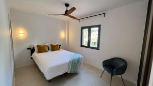 a bedroom with a bed with a ceiling fan and a chair at Casa Goldberg in Paguera