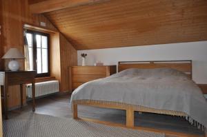 1 dormitorio con cama y techo de madera en Drosera appartement et studio de vacances en La Chaux-du-Milieu