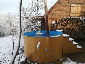 una bañera de hidromasaje en la nieve frente a una casa en Borlova /Muntele Mic, en Borlova