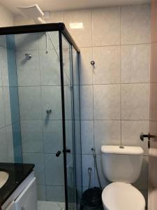 uma casa de banho com um WC e uma cabina de duche em vidro. em APARTAMENTO NA PRAIA DE ITAPARICA em Vila Velha