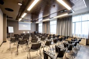 uma sala de conferências com cadeiras e um ecrã em Muraless Art Hotel em Castel d'Azzano