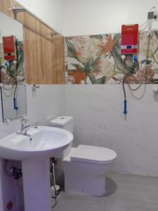 a bathroom with a sink and a toilet and a mirror at KIMURA PENSION in El Nido