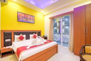 1 dormitorio con 1 cama grande y paredes amarillas en Pandora Twin Towers, en Greater Noida