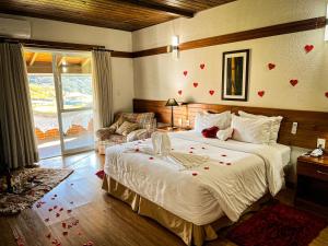 een slaapkamer met een bed met harten aan de muur bij Hotel Fazenda Rota dos Cânions in Bom Jardim da Serra