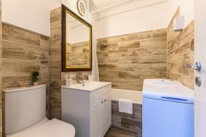 a bathroom with a toilet and a sink and a mirror at JAD - Family Apartments & Studios in Braşov