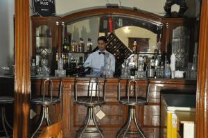 a man standing behind a bar with a mirror at HOTEL CITY HEART in Chamba
