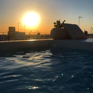 ein Teddybär neben einem Pool bei Sonnenuntergang in der Unterkunft Agata Salento Luxury Home in Matino