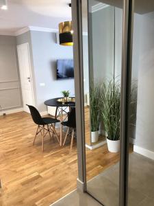 a dining room with a table and some plants at COMFORT GRAŻYŃSKIEGO 7A in Katowice