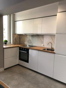 a kitchen with white cabinets and a sink at COMFORT GRAŻYŃSKIEGO 7A in Katowice