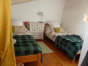 a bedroom with two beds and a dresser with a lamp at Maison des Remparts nichée sous la Cité in Carcassonne