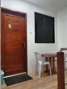 a room with a door and a table and a television at KIMURA PENSION in El Nido