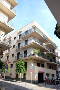 a tall white building with balconies on a street at Sweet Inas in Sitges