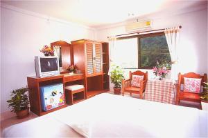 奧南海灘的住宿－J大廈酒店，一间卧室配有一张床,并在一间客房内配有电视。