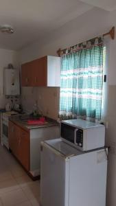 a kitchen with a sink and a microwave at Los Cerezos in La Cumbre