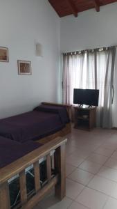 a bedroom with two beds and a flat screen tv at Los Cerezos in La Cumbre