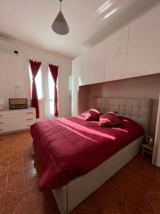 um quarto com uma grande cama vermelha com lençóis vermelhos em House vittone venaria reale 2 em Venaria Reale