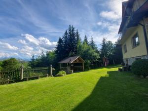 een tuin van een huis met een hek en een huis bij u Lucyny w Białce Tatrzańskiej in Białka Tatrzanska