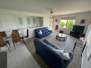 sala de estar con sofá azul y TV en Beach Haven - Beach and Cafes on your doorstep - 3 bedrooms , Sleeps 6, en St Leonards