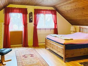 BrålandaにあるHoliday home BRÅLANDA VIのベッドルーム1室(赤いカーテン付きのベッド1台付)