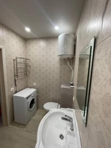a bathroom with a sink and a toilet and a mirror at Подобово ЖК Центральний вул.Нове Шосе, 8А in Bucha
