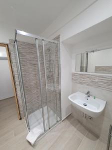 een witte badkamer met een douche en een wastafel bij Appartamento Il Castello in Casale Monferrato