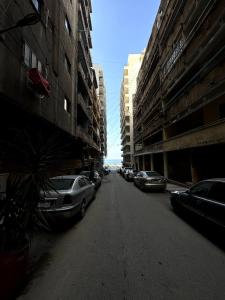 pusta ulica z samochodami zaparkowanymi po bokach budynków w obiekcie Appartement à Miami - Vu sur mer w Aleksandrii