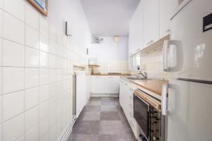 a white kitchen with a sink and a refrigerator at nominoé 9e étage in Blankenberge