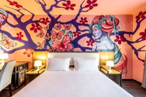 a bedroom with a large bed with a painting on the wall at Muraless Art Hotel in Castel d'Azzano