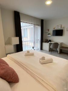 1 dormitorio con 1 cama con 2 toallas en GUEST ROOMS ASENEVTSI CITY CENTER en Veliko Tŭrnovo